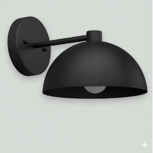 May include: A black wall-mounted light fixture with a dome-shaped shade. The fixture has a circular base and a straight arm connecting to the shade. The light bulb is visible inside the shade.