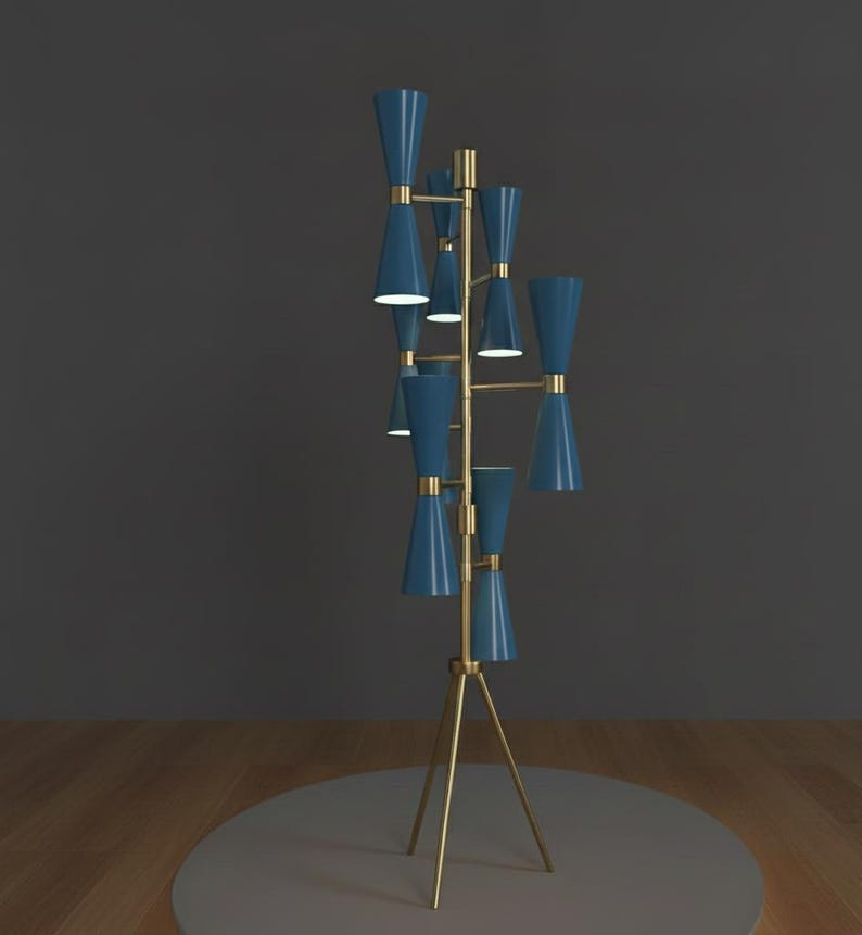 May include: A modern floor lamp with a brass tripod base and multiple blue cone-shaped shades. The lamp has a mid-century modern design, with a series of lights branching out from a central pole. The lamp is approximately 60 inches tall.
