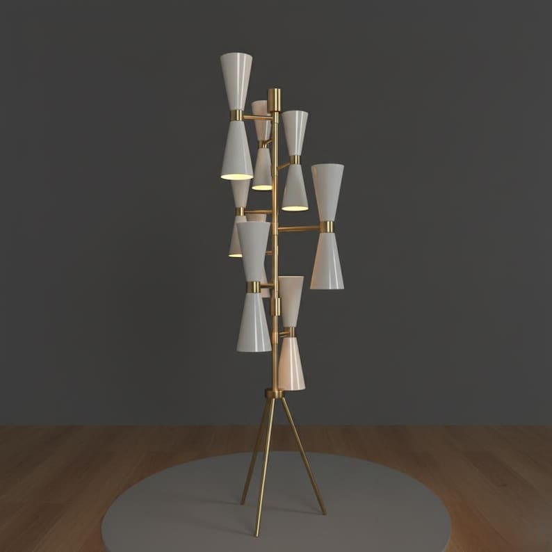 May include: A modern floor lamp with a gold-colored frame and multiple white cone-shaped shades. The lamp has a tripod base and a series of lights arranged vertically. The lamp is on a gray circular base.