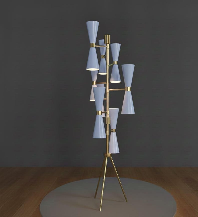 May include: A modern floor lamp with a brass frame and multiple light blue cone-shaped shades. The lamp has a tripod base and a series of lights arranged vertically. The design is sleek and contemporary, suitable for home decor.