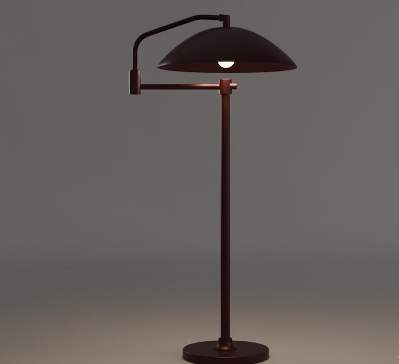 May include: A bronze floor lamp with a curved arm and a dome-shaped shade. The lamp has a circular base and a vertical pole supporting the arm and shade. The light is on, illuminating the shade's interior.
