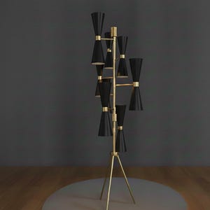 May include: A tall, modern floor lamp with a gold-colored frame and multiple black cone-shaped shades. The lamp has a tripod base and is designed with a mid-century modern aesthetic. The shades are arranged in a tiered fashion.
