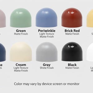 May include: Ten coloured, dome-shaped objects are displayed, including mauve, green, periwinkle, brick red, and yellow. Each dome has a different finish, such as satin or matte. Text on the image indicates the colour names and finishes.