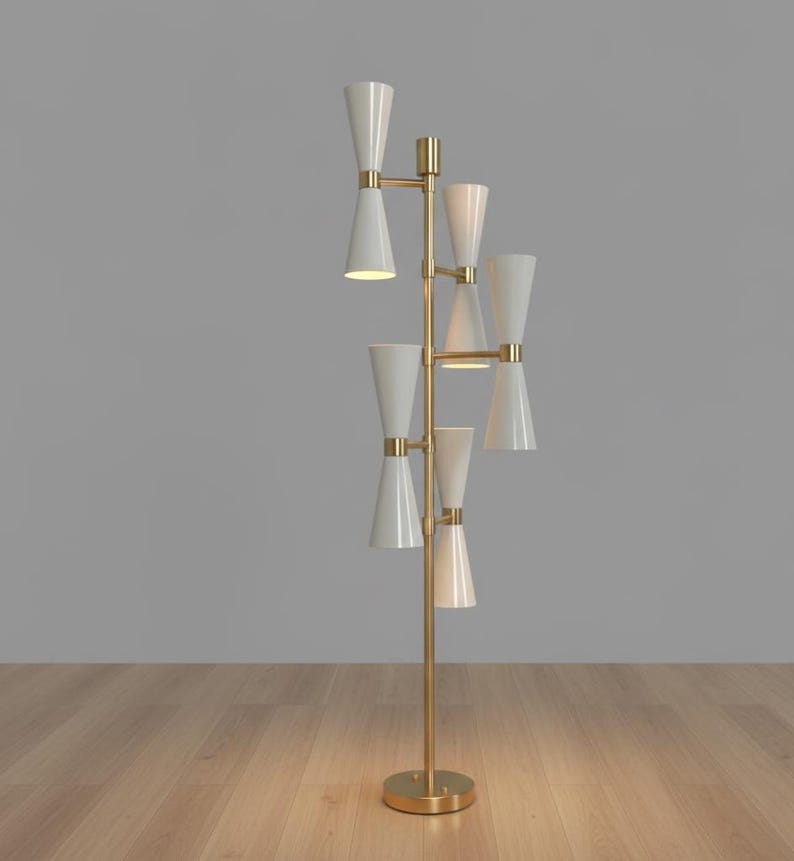 May include: A modern floor lamp with a brass finish and multiple white cone-shaped shades. The lamp has a round base and a tall, vertical design, perfect for illuminating a living room or bedroom.
