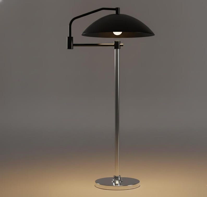 May include: A contemporary floor lamp featuring a black, dome-shaped lampshade and a chrome-plated pole and base. The lamp has an adjustable arm and a single light bulb. The design is minimalist and suitable for various interior styles.