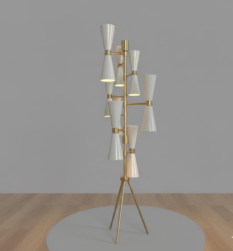 May include: A modern floor lamp with a gold-colored tripod base and a series of white, cone-shaped shades. The lamp has a multi-arm design, with the shades arranged at different heights. The overall design is sleek and contemporary, suitable for various interior styles.