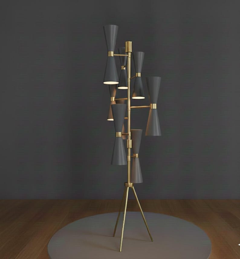 May include: A modern floor lamp with a brass frame and multiple dark gray cone-shaped shades. The lamp has a tripod base and a series of lights that extend upwards. The design is sleek and contemporary, suitable for interior decor.