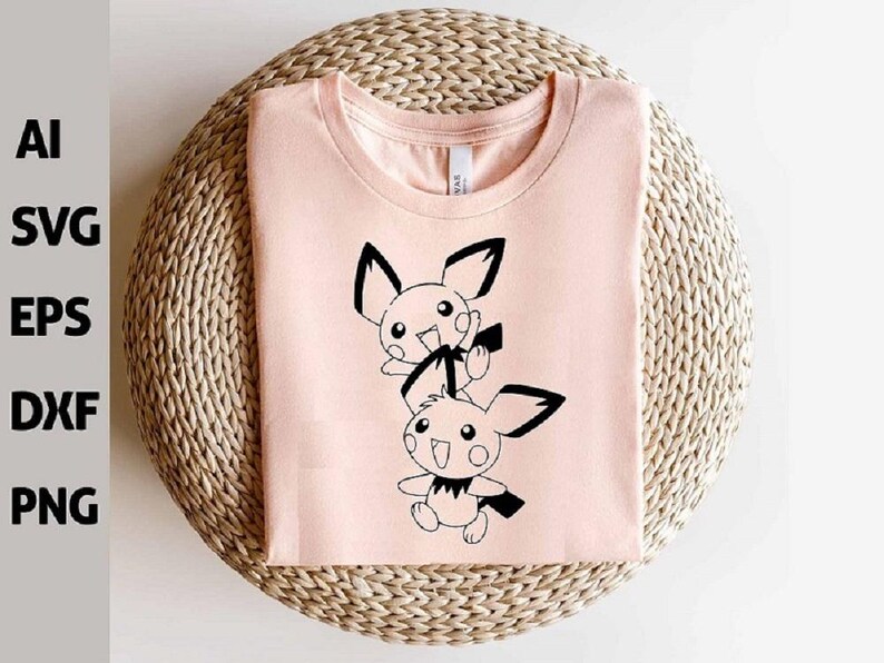 May include: A light pink t-shirt featuring a black and white cartoon graphic of two characters with large ears and smiling faces. The shirt is folded neatly on a woven, circular surface. The image also includes the text "AI SVG EPS DXF PNG".