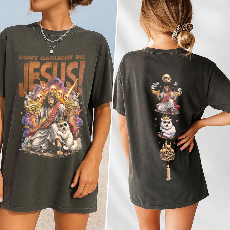 K&ouml;nnte beinhalten: Dunkelgraues T-Shirt mit einer Grafik von Jesus, der Waffen h&auml;lt, umgeben von Totenk&ouml;pfen und dem Text "DON'T GASLIGHT ME JESUS!". Die R&uuml;ckseite des Shirts zeigt ein vertikales Design mit Jesus, einer Katze und Totenk&ouml;pfen.