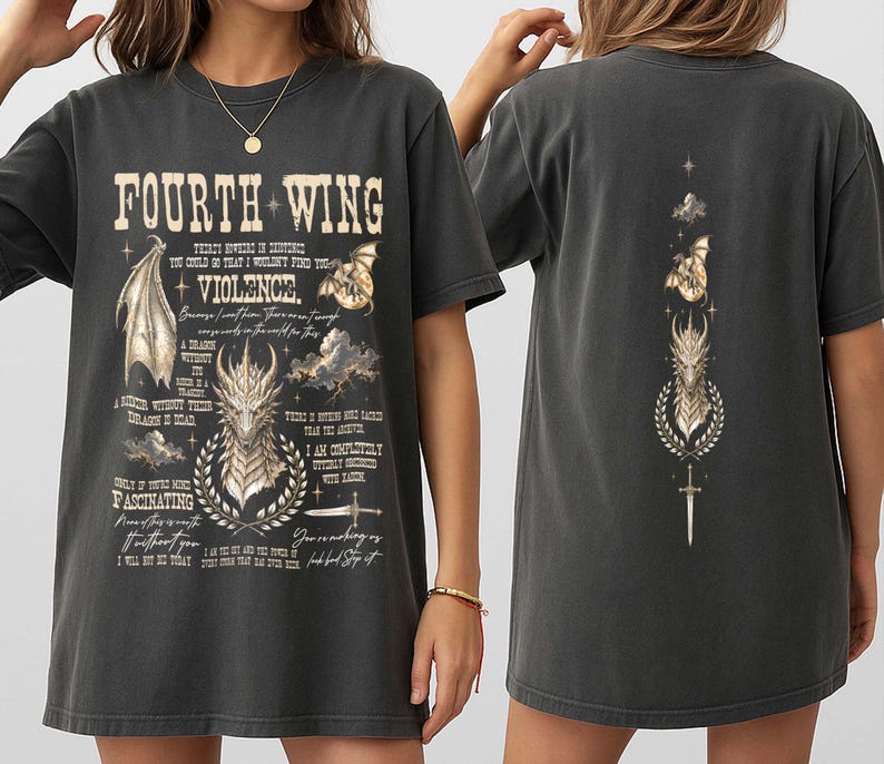 May include: A charcoal gray short-sleeve t-shirt featuring a graphic print. The front displays the text "FOURTH WING" and "VIOLENCE" with dragon illustrations, clouds, a sword, and various quotes. The back features a vertical design of a dragon.