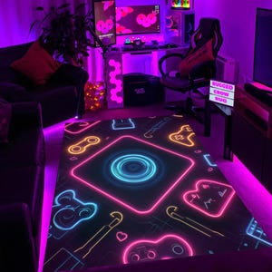Könnte beinhalten: Schwarzer Gaming-Teppich mit Neon-Design mit Spielcontrollern, Herzen und anderen Gaming-bezogenen Symbolen. Der Teppich hat ein zentrales kreisförmiges Design mit neonblauem und pinkfarbenem Leuchten. Die Worte "RUGGED CROW RUG" sind auf einem Schild zu sehen.
