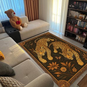 May include: A rectangular area rug featuring two leopards with yellow and black spots, set against a dark background with floral and leaf motifs. The rug has a decorative border and is placed in a living room setting.