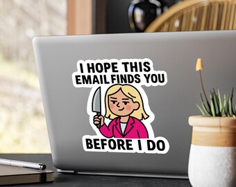 Op de afbeelding: Een sticker op een laptop met een cartoonvrouw die een mes vasthoudt. De tekst luidt: "I HOPE THIS EMAIL FINDS YOU BEFORE I DO." De vrouw draagt een roze blazer en heeft blond haar. Humoristisch ontwerp.
