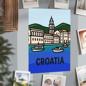 May include: A poster depicting a Croatian coastal scene with boats, buildings, and green hills under a blue sky. The word "CROATIA" is printed in white block letters at the bottom of the poster.