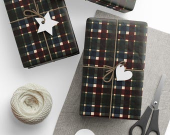 May include: Gift-wrapped boxes with a plaid pattern in shades of green, navy, and burgundy. Each box is tied with twine and a white tag. A ball of twine, scissors, and blank tags are also present.