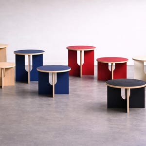 Combinazione di 2 sgabelli moderni in compensato, uno alto e uno basso.