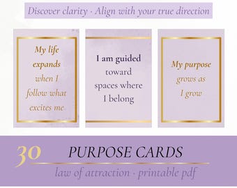 May include: A collection of 30 purpose cards with gold text and borders on a lavender background. The cards display affirmations like "My life expands when I follow what excites me." The text "Discover clarity. Align with your true direction" is at the top.