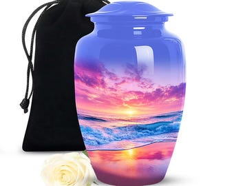 May include: A blue cremation urn with a sunset scene, a black velvet bag, and a white rose. The urn features a glossy finish and a lid. The sunset design includes shades of pink, orange, and blue.