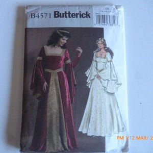 May include: A sewing pattern for two medieval-style gowns. The pattern is from Butterick and has the number B4571 on it. One gown is red with gold trim and the other is white with gold trim.