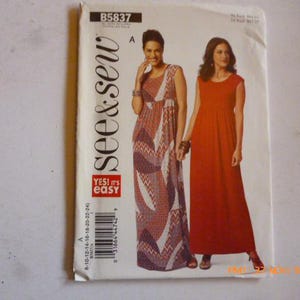 May include: A sewing pattern envelope featuring two women modeling maxi dresses. One dress is a patterned mix of red, white, and purple. The other is a solid red. The envelope has the text "see & sew" and "YES! it's easy".