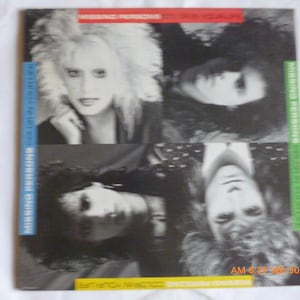 May include: Album cover for Missing Persons' album, featuring four black and white portraits of band members. The album title and band name are displayed in various colored bars. The album is titled "Color in Your Life".
