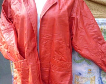 May include: A red leather blazer with a notched collar and two front pockets. The jacket is displayed on a white mannequin and has a classic, tailored design. The blazer is a vibrant shade of red.