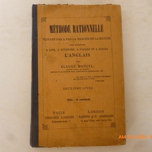 May include: A vintage book with a tan cover and black spine. The cover features French text in black, including "MÉTHODE RATIONNELLE" and the author's name, Claude Marcel. The book is titled "DEUXIEME LIVRE".