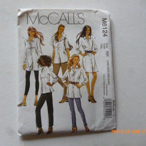 May include: A white McCall's M6124 sewing pattern envelope featuring illustrations of five different shirt styles. The text includes the brand name McCall's, the pattern number M6124, and size range 18W-20W-22W-24W printed on the front cover.