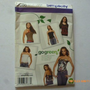 May include: A Simplicity sewing pattern envelope, number 2966, featuring various strapless top designs. The white packaging displays multiple photographs of garments, the text go green, and a barcode at the bottom. The top border is purple.