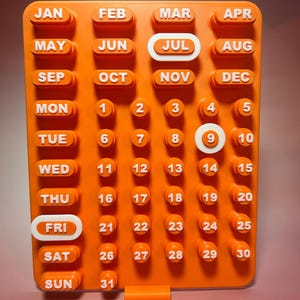 May include: Orange, modular calendar with white lettering and numbers. Months of the year are listed across the top, days of the week on the left, and dates in a grid. The current date is July 9th.