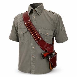 Puede incluir: Una camisa de manga corta color verde oliva con charreteras y un parche acolchado en el hombro derecho, usada con una bandolera de cuero color burdeos oscuro con remaches plateados, cartucheras y una funda a juego con un revólver.