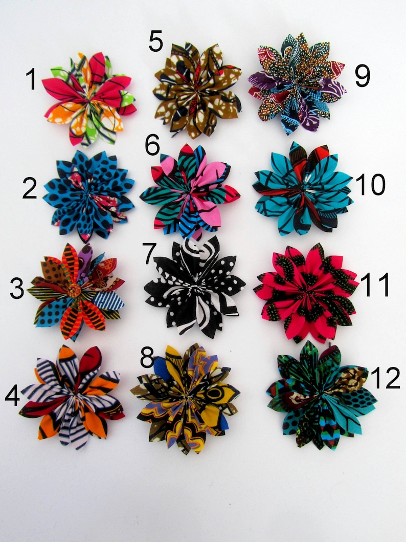 May include: Twelve fabric flower hair clips in various colors and patterns. The flowers are made from colorful African wax print fabric. The clips are numbered 1 through 12.