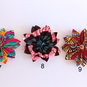 May include: Three fabric flowers with colorful patterns. The flowers are pink, red, and black with yellow accents. The flowers are numbered 7, 8, and 9.