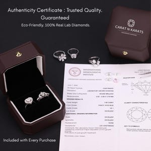 May include: An open brown jewelry box displays two diamond rings, with three additional rings visible. A certificate from the International Gemological Institute is also present, along with a Carat N Karats box. The text reads "Authenticity Certificate: Trusted Quality."
