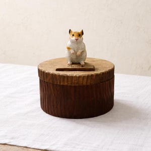 May include: A set of three ceramic mugs with a speckled, matte finish in cream, light brown, and dark brown. Each mug features a minimalist design and a rounded handle.