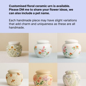 May include: A collection of handmade ceramic urns with floral designs. Each urn features a white base and lid, adorned with hand-painted flowers in various colors. The text in the image says, "Customised floral ceramic urn is available."