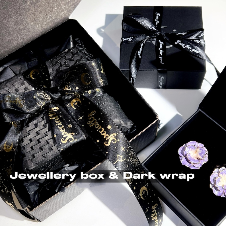 May include: Black jewelry boxes with black ribbon and gold text. One box is open, revealing black tissue paper and a decorative ribbon. Another box is closed with a ribbon that says "Just for you". The text "Jewellery box & Dark wrap" is visible.