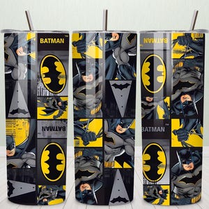 May include: Three Batman-themed tumblers with straws. Each tumbler features a repeating pattern of Batman images, the Batman logo, and the word "Batman" in a yellow and black color scheme. The background is a mix of gray and yellow squares.