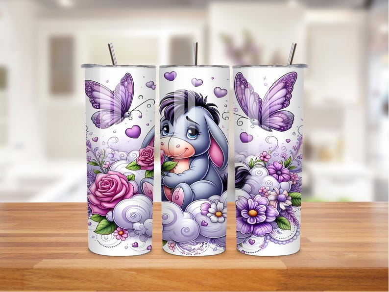 May include: Three white stainless steel tumblers with a cartoon donkey design. Each tumbler has a different design, including purple butterflies, roses, and floral accents. The design is in shades of purple, pink, and white.