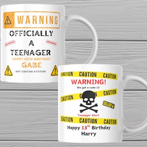 May include: Two white ceramic mugs featuring birthday designs. The left mug has orange and black text reading WARNING OFFICIALLY A TEENAGER HAPPY 13TH BIRTHDAY GABE MAY CONTAIN ATTITUDE. The right mug has yellow caution tape, a skull, and text reading CAUTION WARNING! We got a code 13 Teenager Alert Happy 13th Birthday Harry.