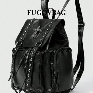 Può includere: Zaino nero con borchie argentate e una croce decorativa sulla patta. Lo zaino ha più tasche e spallacci regolabili. Il testo "FUGU VBAG" è stampato sulla parte superiore della borsa.