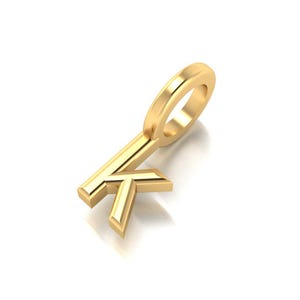Könnte beinhalten: Ein goldfarbener Anhänger in Form des Buchstabens "K". Der Anhänger hat oben eine Schlaufe für eine Kette und ist vor einem weißen Hintergrund platziert. Der Anhänger ist wahrscheinlich aus Metall.