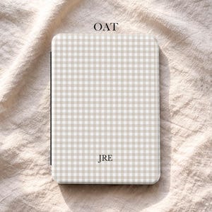 May include: A rectangular case with a beige and white gingham pattern. The word "OAT" is at the top, and "JRE" is in the center. The bottom has the word "UBLS" in a circle.