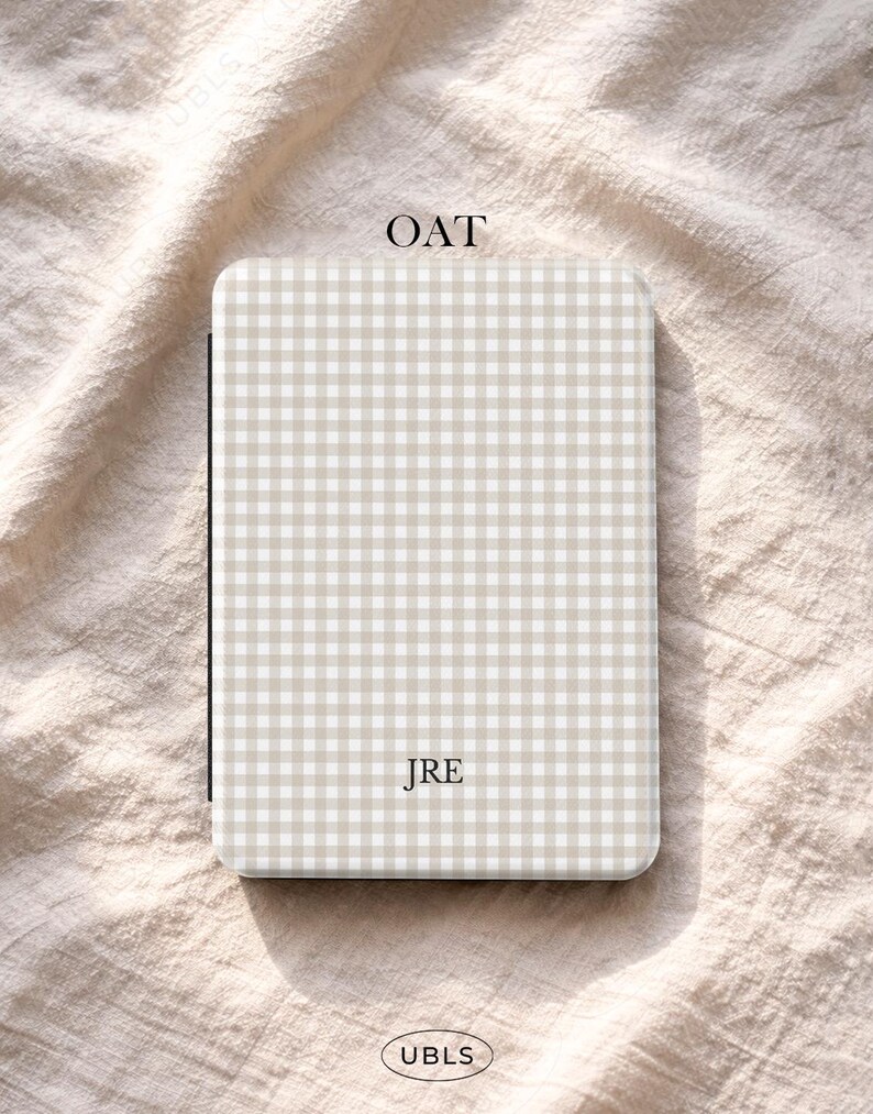 May include: A rectangular case with a beige and white gingham pattern. The word "OAT" is at the top, and "JRE" is in the center. The bottom has the word "UBLS" in a circle.