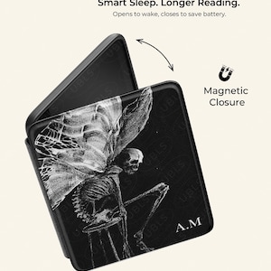 May include: A black e-reader case with a magnetic closure, featuring a white skeletal fairy illustration and the initials A.M. Text reads: Smart Sleep. Longer Reading. Opens to wake, closes to save battery. Magnetic Closure. UBLS.