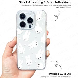 May include: Clear phone case with a white bunny and star pattern. The case is shown with the text "Shock-Absorbing & Scratch-Resistant" and "Precise Cutouts". The case is designed to protect the phone from drops and scratches.