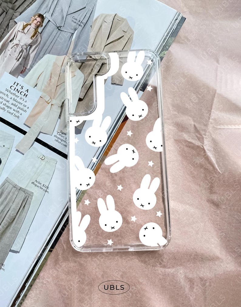 May include: Clear phone case with a white bunny and star pattern. The case has a transparent design, allowing the phone's color to show through. The bunnies have a simple, cartoon-like style.