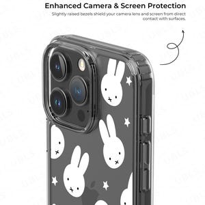 May include: Clear phone case with a repeating pattern of white bunny faces and stars on a dark gray background. The case has a protective design with slightly raised bezels to shield the camera lens and screen.