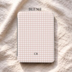 May include: A rectangular case featuring a blush pink and white gingham design. The word "BLUSH" is printed at the top, and the initials "CB" are in the centre. The brand name "UBLS" is at the bottom.