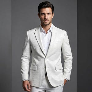 Può includere: Un blazer bianco con una texture in rilievo effetto pelle di coccodrillo, revers dentellato, due bottoni frontali e due tasche con patta. Il blazer è indossato sopra una camicia bianca abbottonata, creando un look monocromatico e strutturato.